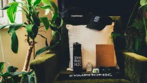 An eco-friendly chair with a bottle of water, a hat, and a plant.