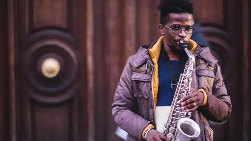 Young man, saxophone, wooden door.