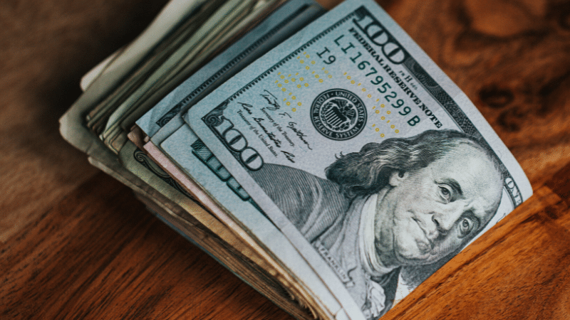 A stack of dollar bills - Ways musicians can make money.