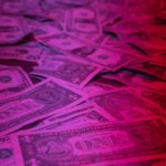 A pile of money illuminated on a dark background, symbolizing performing rights.