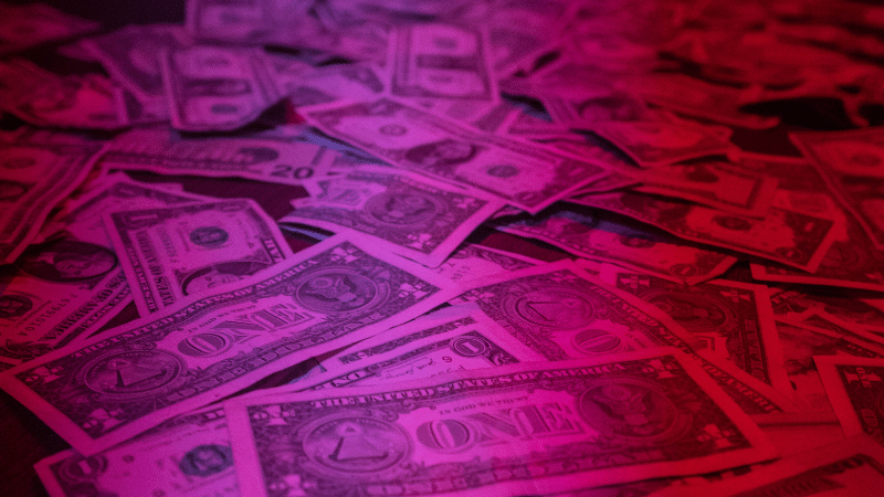 A pile of money illuminated on a dark background, symbolizing performing rights.