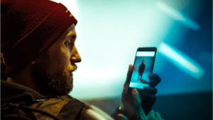 A man wearing a beanie looking at his phone.