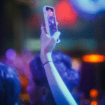 A group of people at a nightclub taking a TikTok video with their cell phone.