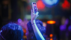A group of people at a nightclub taking a TikTok video with their cell phone.