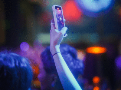 A group of people at a nightclub taking a TikTok video with their cell phone.