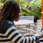 A woman using a laptop for management tasks at a table.