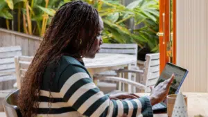 A woman using a laptop for management tasks at a table.