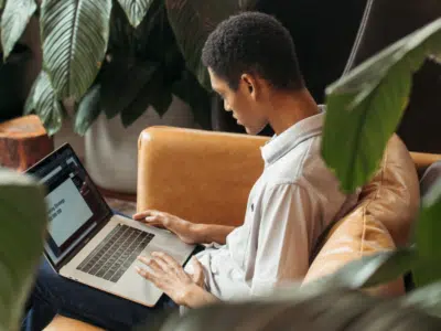 A couple engaged in marketing activities on a couch using a laptop.