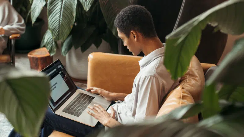 A couple engaged in marketing activities on a couch using a laptop.