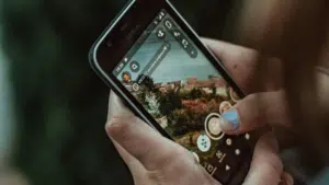 A person holding up a smartphone with a TikTok picture on it.