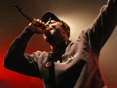 A man singing into a microphone with fans.