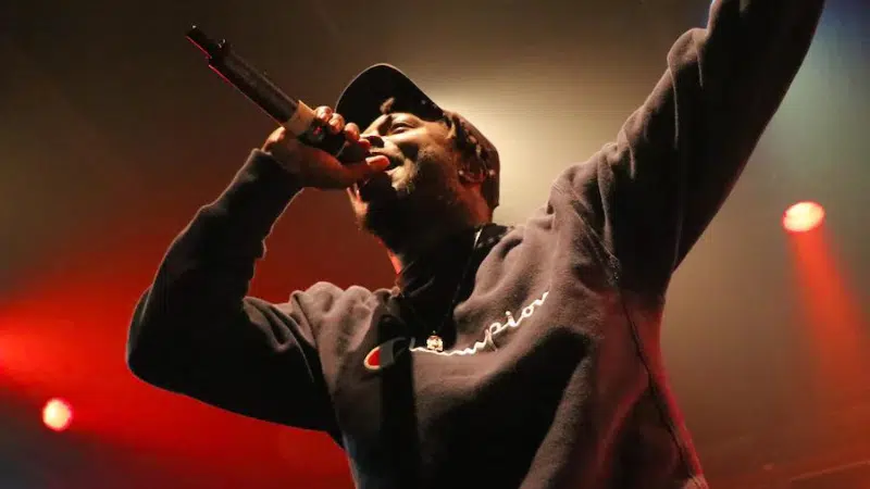 A man singing into a microphone with fans.