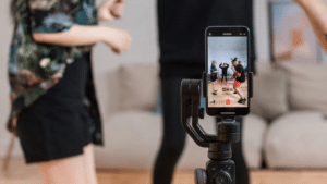 A woman is taking a TikTok video selfie with a cell phone.