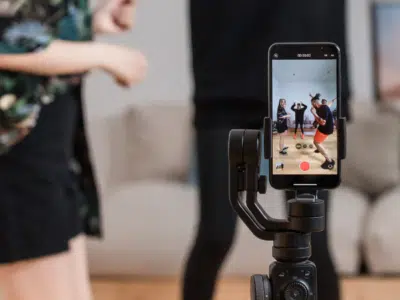 A woman is taking a TikTok video selfie with a cell phone.