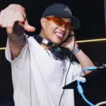 A man on a tour is pointing at a DJ.