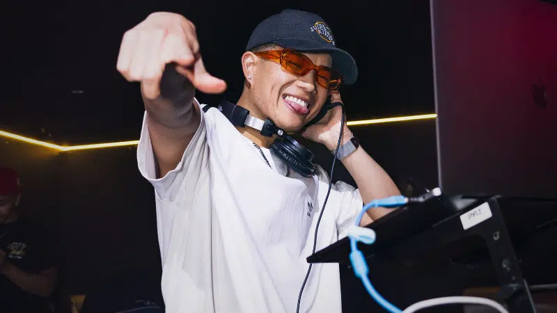 A man on a tour is pointing at a DJ.