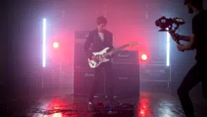 A man is playing an electric guitar in a dark room, video.