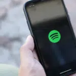 A person holding an iPhone with Spotify for Artists on it.