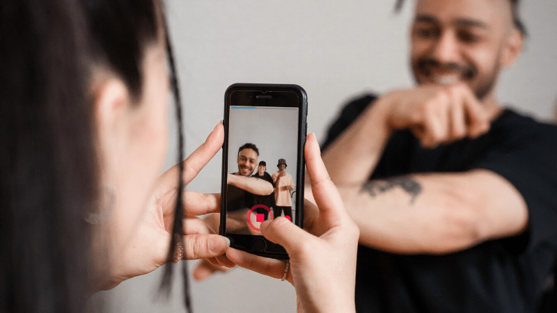 A couple capturing a TikTok video with their cell phone.