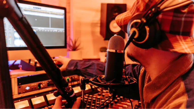 A man in a music studio with a microphone.