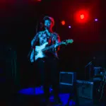 A man playing a guitar on a Nashville stage.