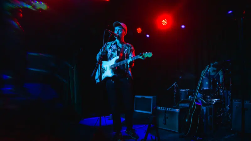 A man playing a guitar on a Nashville stage.