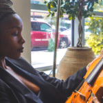 A woman playing music on a violin.