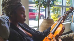 A woman playing music on a violin.