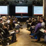 A group of people attending a conference at M for Montréal.