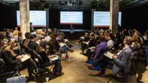 A group of people attending a conference at M for Montréal.