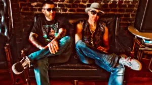 Two men enjoying fresh new music while sitting in a chair.