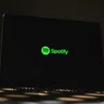 A laptop screen showcases the Spotify logo in vibrant green against a dark backdrop, hinting at the highly anticipated Spotify Wrapped experience.