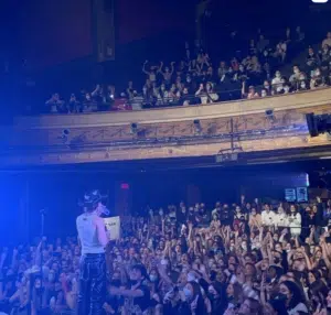 A crowd of people at a concert in a large auditorium in Los Angeles.