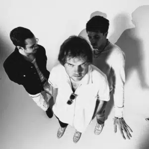 A black and white photo of a group of men standing in a shadow.