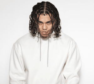 A man with dreadlocks wearing a white hoodie.
