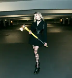 A woman holding an ax in a parking garage.