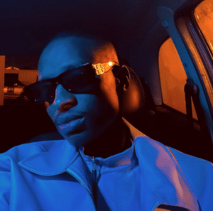 A man in sunglasses sitting in a car at night.