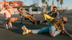 Four Gen Z individuals wearing roller skates striking playful poses in a parking lot at sunset.