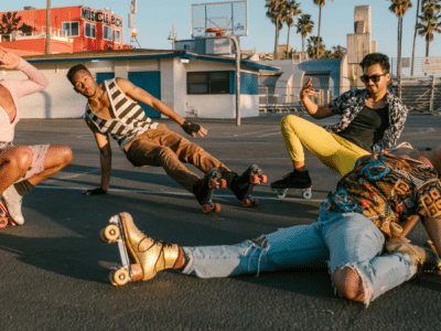 Four Gen Z individuals wearing roller skates striking playful poses in a parking lot at sunset.