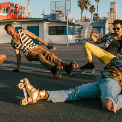 Four Gen Z individuals wearing roller skates striking playful poses in a parking lot at sunset.