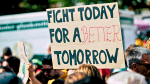A group of people are holding a sign that reads, "Fight today for a better tomorrow," at a protest or rally.