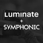 A dark background with the text "Luminate + Symphonic" in bold white letters. Multiple hands holding smartphones, each screen glowing softly, are visible in the background.