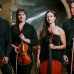 Four people stand unfiltered, holding string instruments against an abstract background.