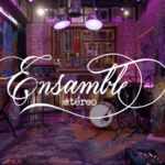 A colorful, artistic music studio with instruments set up, including drums, guitars, and keyboards. The sign "Ensamble Etéreo" is prominently displayed in elegant cursive script, inviting musicians to create ethereal ensembles.