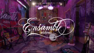 A colorful, artistic music studio with instruments set up, including drums, guitars, and keyboards. The sign "Ensamble Etéreo" is prominently displayed in elegant cursive script, inviting musicians to create ethereal ensembles.