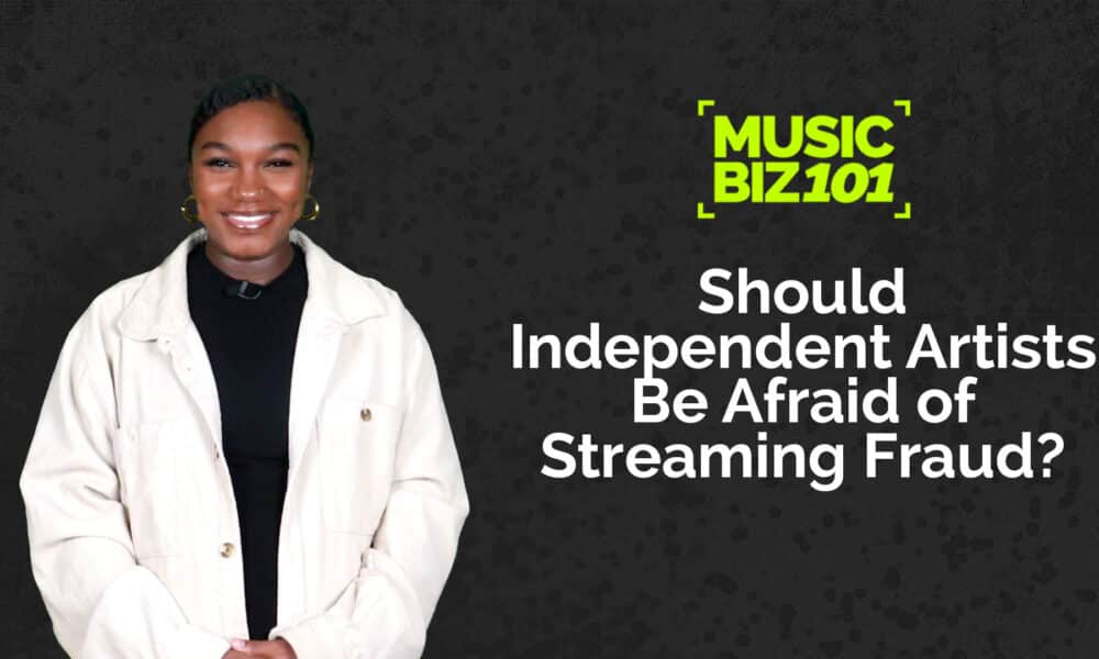 A person in a white jacket stands against a dark background with text: "MUSIC BIZ 101: Should Independent Artists Be Afraid of Streaming Fraud?