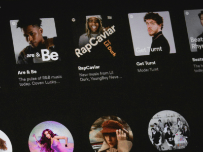 A digital music playlist interface displays various curated playlists with titles such as "Are & Be," "RapCaviar," "Get Turnt," and "Beats & Rhymes." Circular album art is featured below each playlist title.