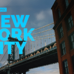 A view of a bridge in New York City with large blue text overlay reading "New York City" and a nearby brick building.