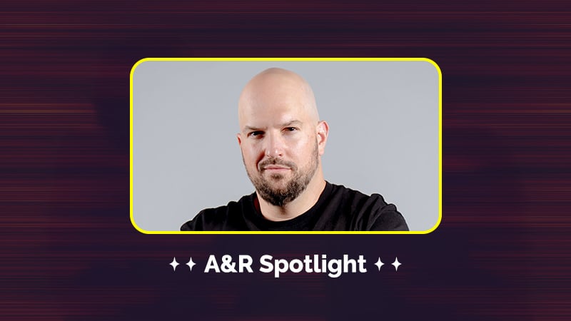 A bald man with a beard is shown in a framed box with the text "A&R Spotlight" below. The background is dark with a gradient design.