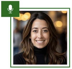 A woman with long brown hair smiles at the camera. She is wearing a black turtleneck. There is a green square with a microphone icon in the upper left corner.